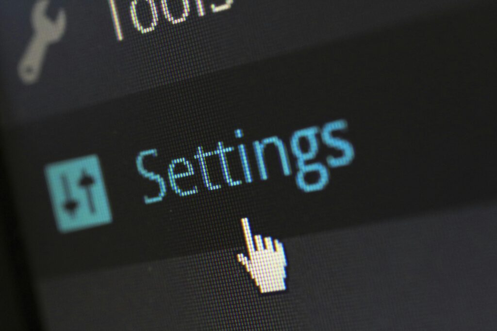 A close-up photo of a computer screen showing the settings button with a cursor hovering over it.